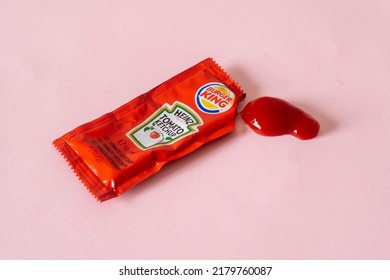 ALGECIRAS, SPAIN - June, 28, 2022: Opened Single Pack Of Heinz Brand Ketchup From Burger King And Ketchup Blob On Pink Background