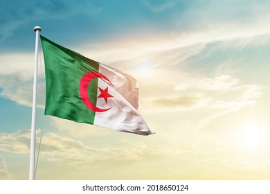 Algeria national flag waving in beautiful clouds.