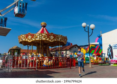 Algiers, Algeria - June 10, 2021: Young Arab Boy Wearing A Face Mask And Running Inside The Amusement Park.