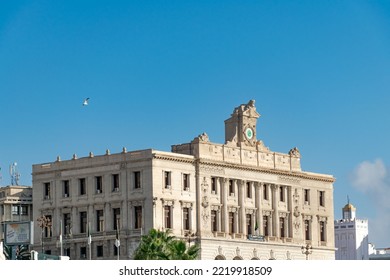 Algiers, Algeria - October 14, 2022: The Chamber Of Commerce Old Consular Palace With A French  Engraving, Arab Panel And A Clock On The Roof. Flying Bird In A Sunny Day With Blue Sky In Background