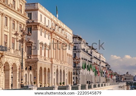Algiers, Zirout Youcef Boulevard, Council of the Nation, Bank of Algeria and Casbah municipality white buildings with arab league flag poles, electric street post lights and chamber of commerce Foto stock © 