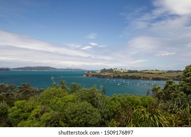 Algies Bay On Matakana Coast Near Snells Beach. Sunny Day After A Storm. View From Highfields Garden Reserve To Kawau Island And Hauraki Gulf. Boating Paradise. Native Trees Foreground. Boats At Sea.