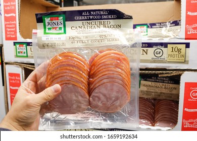 Alhambra, California, United States - 02-19-2020: A Hand Holds A Package Of Jones Dairy Farm Uncured Canadian Bacon, On Display At A Local Big Box Grocery Store.