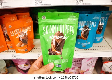 Alhambra, California/United States - 02/19/2020: A hand holds a package of Skinny Dipped Almonds, on display at a local grocery store. 