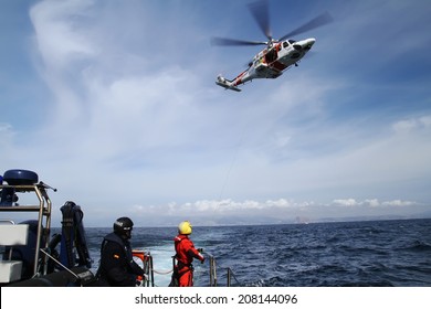 ALICANTE COAST, SPAIN - JULY 5: The helicopter of the Spanish  Maritime Rescue Team and his rescuers training over the deck of a coast guard ship, on july 5, 2014 in Alicante coast.