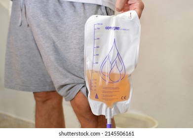 Alicante, Spain - February 13, 2022: Corysan urine (catheter) bag has non-return valve,drain valve, protective layer non-woven fabric and has no measurement function is held by man.
