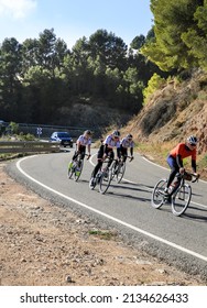 Alicante, Spain- February 4, 2022: Group Of Female Cyclists Riding On A Mountain Road In Alicante On A Sunny Day Of Summer