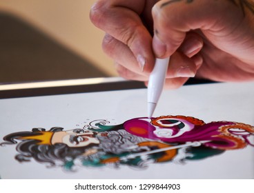 ALICANTE TATTOO FAIR CIRCA 2018 tattoo artist drawing a sketch on a tablet