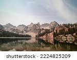 Alice Lake, a large alpine lake in Idaho’s Sawtooth Mountains seen on a summer day. The lake is within the Sawtooth Wildeness and Sawtooth National Forest and is a popular hiking destination.
