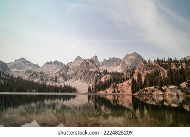 Alice Lake, a large alpine lake in Idaho’s Sawtooth Mountains seen on a summer day. The lake is within the Sawtooth Wildeness and Sawtooth National Forest and is a popular hiking destination.