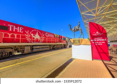 Alice Springs, Northern Territory, Australia - Aug 29, 2019: Carriages Of Famous Ghan Railway At A Morning Stop In Alice Springs Train Station And The Ghan Memorial: Statue Of Afghan Worker And Camel.