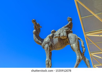 Alice Springs, Northern Territory, Australia - Aug 29, 2019: Details Of The Ghan Memorial: Statue Of Afghan Worker And Camel In Alice Springs Train Station. Sunny Day In The Blue Sky.