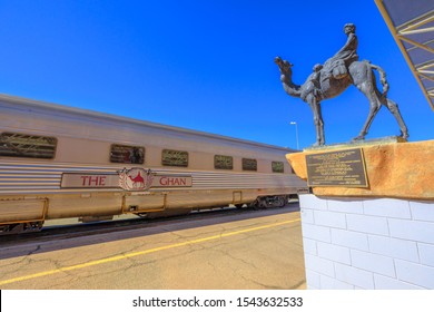 Alice Springs, Northern Territory, Australia - Aug 29, 2019: Carriages Of Famous Ghan Railway At A Morning Stop In Alice Springs Train Station And The Ghan Memorial: Statue Of Afghan Worker And Camel.