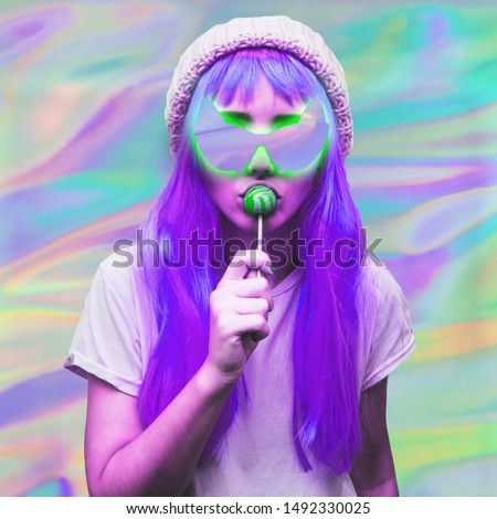  Alien girl eats lollipop in sunglasses with empty space and green light on holographic background.