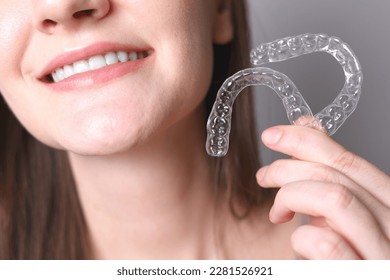 Aligners for straightening teeth in a woman's hand - Shutterstock ID 2281526921