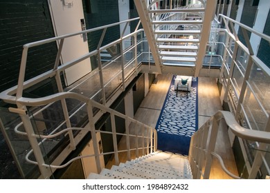 Alkmaar, The Netherlands-June 2021; High Angle View Into Steel Stairway Into Hallway With Prison Cells Of Former Prison Now Renovated Boutique The Fallon Hotel Retaining The Original Interior Features