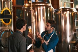Its All About The Flavor. Shot Of Two Young Working Men Doing Inspection Of Their Beer Making Machinery Inside Of A Beer Brewery During The Day.