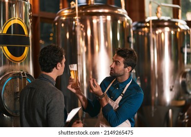 Its all about the flavor. Shot of two young working men doing inspection of their beer making machinery inside of a beer brewery during the day. - Powered by Shutterstock