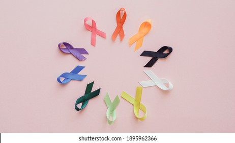all color ribbons on pink background, cancer awareness, World cancer day, National cancer survivor day, world autism awareness day - Shutterstock ID 1895962366