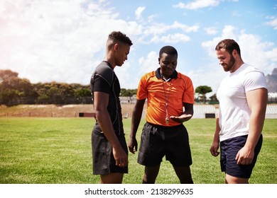 It All Comes Down To The Coin Toss. Shot Of A Referee Flipping A Coin Before A Rugby Game.