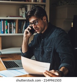 I'm All Ears. Shot Of A Handsome Young Businessman Making A Phone Call While Working In His Office At Home.