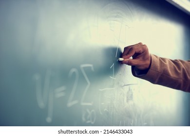 Its All Greek To Me. Cropped Image Of A Teacher Writing A Formula On A Blackboard.