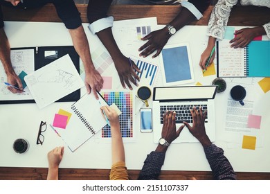 All Hands In For A New Creative Project. High Angle Shot Of A Group Of Businesspeople Having A Meeting In A Modern Office.