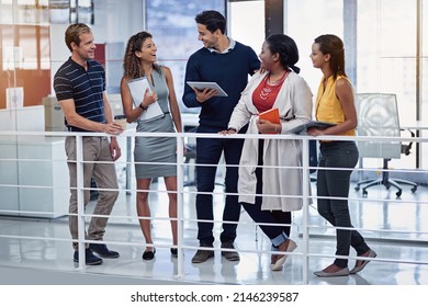 All Hands On Deck For This Meeting. Shot Of A Group Of Colleagues Working Together On A Digital Tablet In An Office.