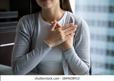 With all my heart! Close up of young lady hands folded close to heart in peaceful candid sincere sign gesture appreciating destiny god for help, expressing heartfelt thank you to friend mate colleague
