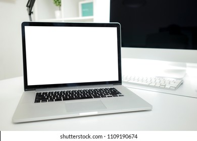 All in one computer, mouse, keyboard, old book, pen, coffee cup and plant vase on wooden table