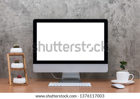 All in one computer, mouse, keyboard, cactus pots, plant vase and coffee cup on wooden table