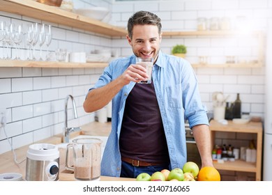 All The Vitamins I Need In One Glass. Shot Of A Young Man Making A Health Smoothie At Home.