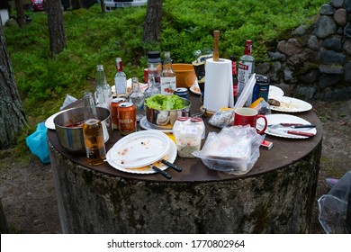 Pärnumaa/Estonia-06.13.2020: All Whats Left After A Nice Party Outside. Empty Bottles, Alcohol, Food Left Overs. Old Well Top Used As Table. Grill Party In The Forest. Mid Summer Fest In Estonia. 