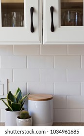 All White Kitchen Cabinet With Dark Handles, White Subway Tile And White Counter Top Decorations.