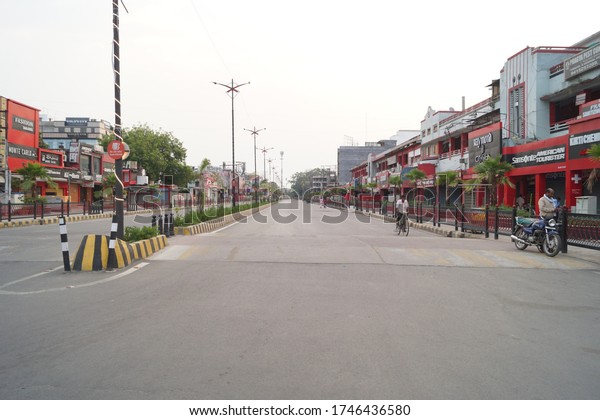 Allahabad,India; May 31,2020  A market in lock down\
during corona virus spread, all shops  in red,black and white color\
closed,few people on the\
road.
