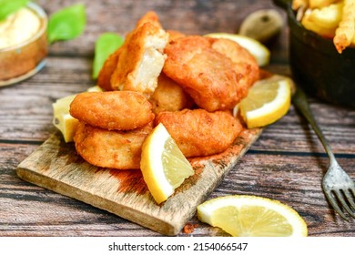   Allasca Pollock Fish  Bites in a crispy Tempura  Batter.Fish and chips .Close up of   crispy breaded  deep fried fish fingers with breadcrumbs s erved with remoulade sauce and  lemon