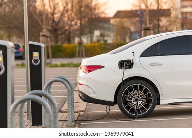 An all-electric car at a charging station - Shutterstock ID 1969979041