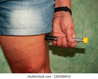 An allergic woman injecting an adrenaline injection into her thigh