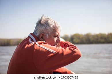 Allergies Are The Worst. Senior Man Has A Cough Sitting By The Lake.