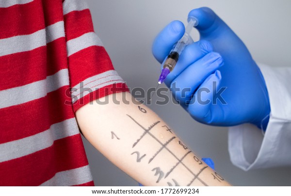An allergist doctor makes a skin test for\
allergies. The boy is being examined in the laboratory, waiting for\
a reaction to allergens.