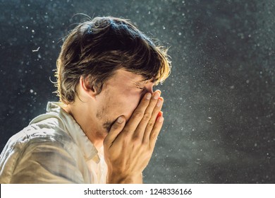 Allergy to dust. A man sneezes because he is allergic to dust. Dust flies in the air backlit by light - Powered by Shutterstock