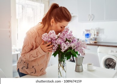 Allergy Free. Happy Woman Smelling Lilac In Modern Kitchen. Seasonal Allergy Concept.