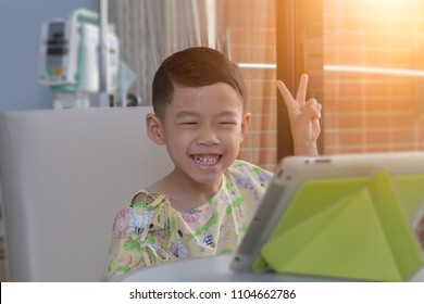Allergy Sickness Asian Black Hair Kid With Happiness And Big Smile Background. Alone 4 Year Old Patient Boy In Hospital Room Using Tablet Video Call To School And Talking With His Teacher And Friends