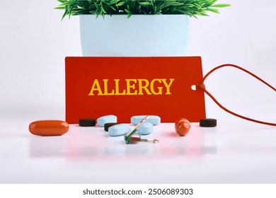 Allergy text written on a red card, with pills, vitamins in the foreground on a white background - Powered by Shutterstock