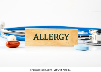 Allergy text written on a wooden block with a stethoscope lying next to it, pills, vitamins on a white background - Powered by Shutterstock