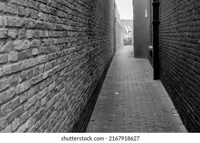 Alleyway Between The Building With Bricks Wall, Classic Vintage Black And White With Small Street Lane, Narrow Path In The City Center With Dwellings.