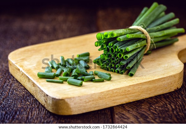Allium schoenoprasum, popularly known as\
chives, chives or chives, in Portugal, is a plant originally from\
Europe. Close up, chopped on wooden\
board.