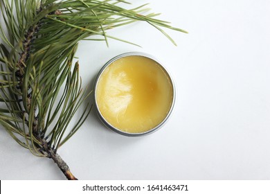 All-natural yellow healing salve next to a pine branch. Top view.  - Shutterstock ID 1641463471