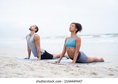 Allow All Your Senses To Feel A Sense Of Calm. Shot Of A Young Man And Woman Practising Yoga Together At The Beach.