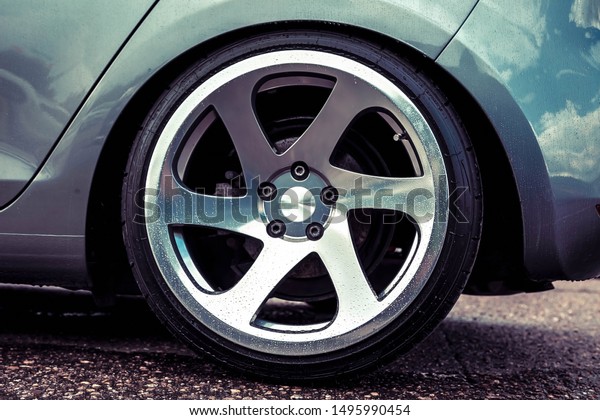 Alloy wheels of a sports car. Polished to shine.\
On a gray car. Closeup